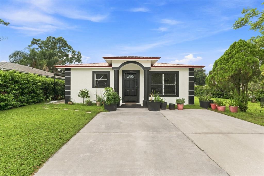 A single-story house with a white exterior, black trim, and a concrete driveway — 1801 BETHUNE DRIVE, PLANT CITY, FL