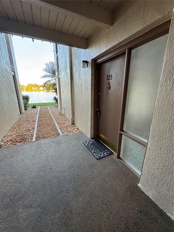 An exterior view of a brown apartment door numbered 225 with a concrete patio — 620 ORANGE DRIVE UNIT 225, ALTAMONTE SPRINGS, FL