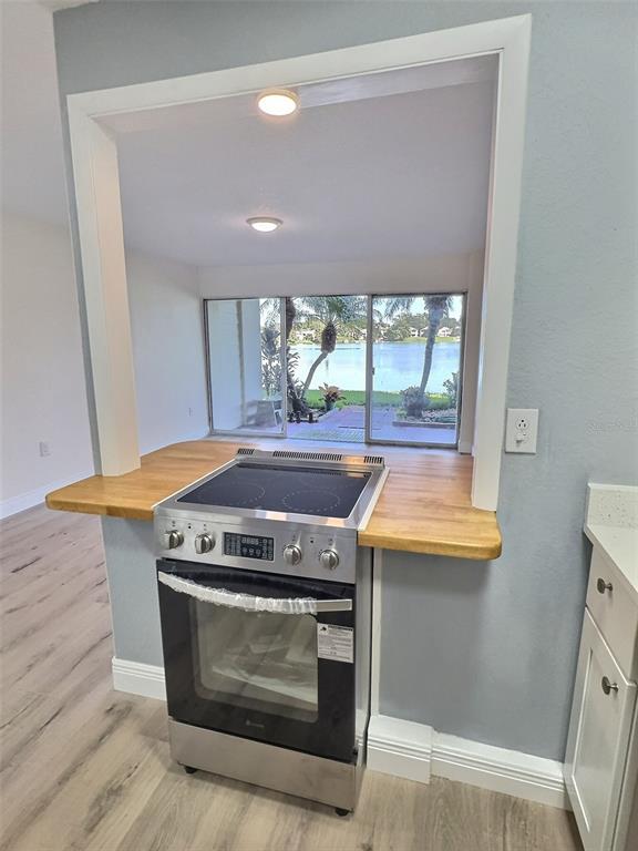A stainless steel electric range sits in a kitchen pass-through window overlooking a lake — 620 ORANGE DRIVE UNIT 225, ALTAMONTE SPRINGS, FL