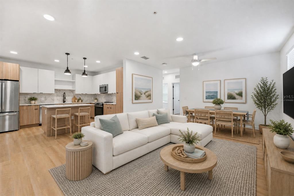 An open-concept living room and kitchen featuring light wood flooring and white cabinetry — 2285 CROWN VILLAGE ROAD UNIT TH1, OCOEE, FL