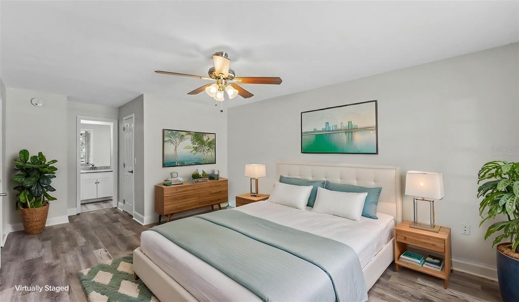 A bedroom with a queen bed, wood-look flooring, a ceiling fan, and an attached bathroom — 4520 OLD COLONY ROAD, MULBERRY, FL