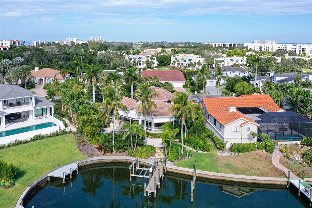 An aerial view of a waterfront house with a pool, dock, and orange-tiled roof — 510 HARBOR GATE WAY, LONGBOAT KEY, FL
