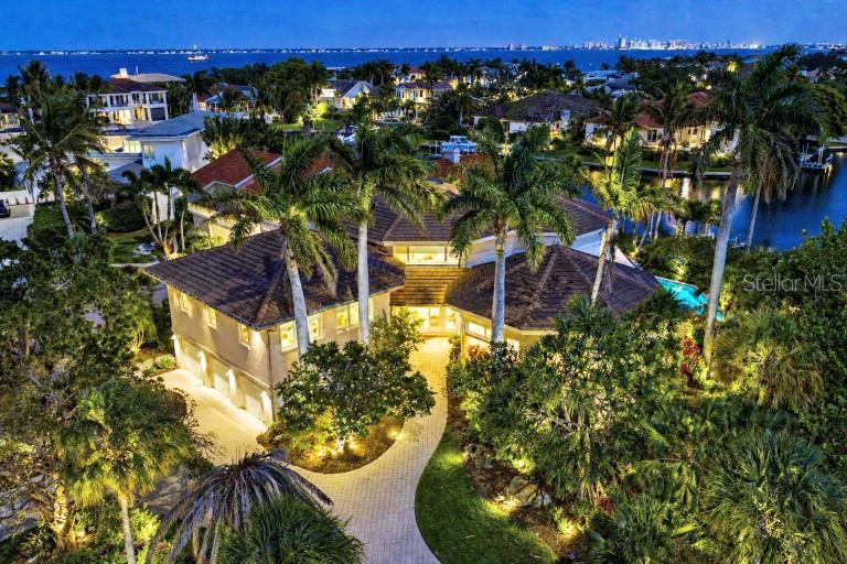 A red convertible is parked on a paved driveway in front of a large house — 510 HARBOR GATE WAY, LONGBOAT KEY, FL