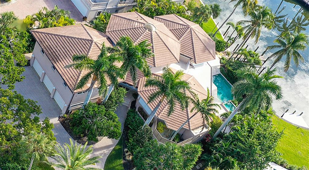 An aerial view of a multi-roofed house with a swimming pool and surrounding palm trees — 510 HARBOR GATE WAY, LONGBOAT KEY, FL