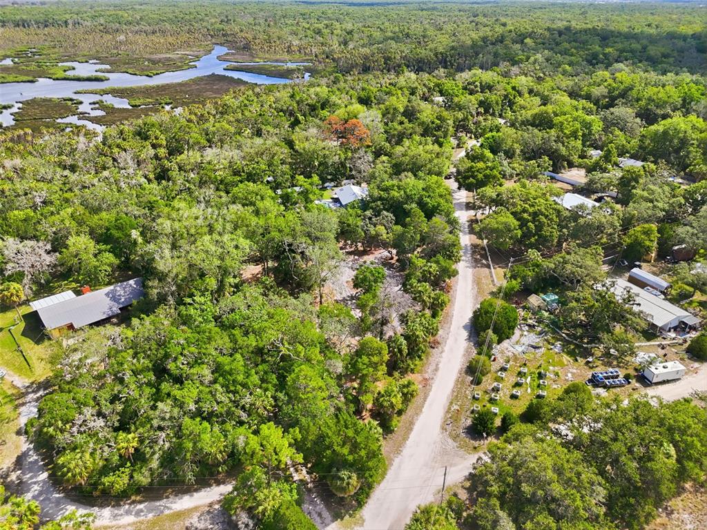 An aerial view shows a rural road winding through a wooded area near a waterway — JEBERT DRIVE, ARIPEKA, FL