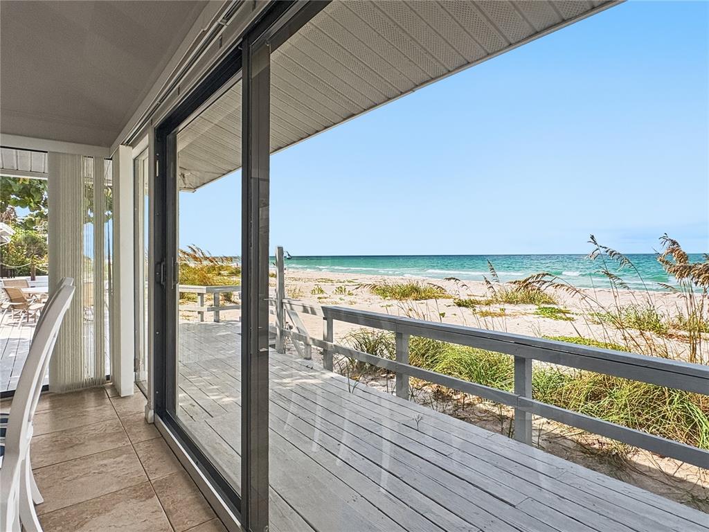 A living room features a white sectional sofa, a coffee table, and wall-mounted mirror decor — 2823 GULF OF MEXICO DRIVE, LONGBOAT KEY, FL