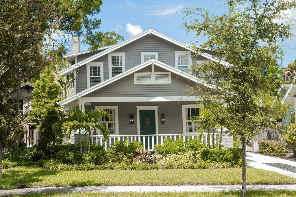 A dark green front door with a decorative glass insert is flanked by two wall sconces — 605 S ORLEANS AVENUE, TAMPA, FL