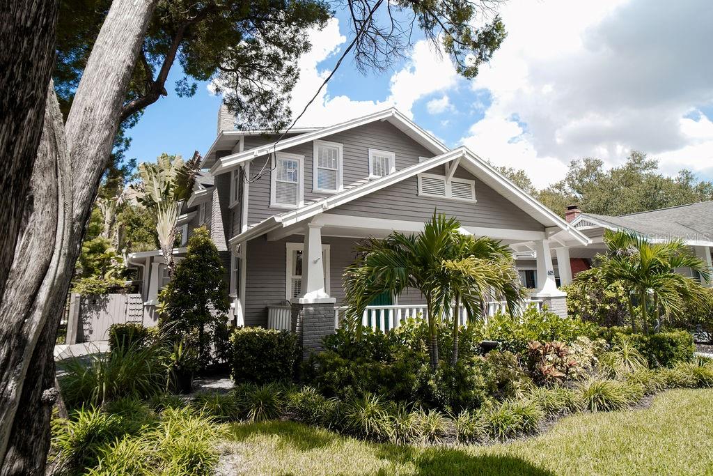 A stone walkway leads between a house with gray siding and a wooden privacy fence — 605 S ORLEANS AVENUE, TAMPA, FL