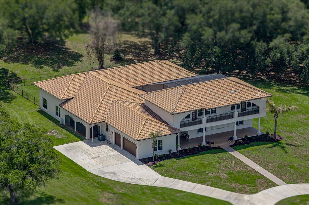 An aerial view shows a large house with a multi-level deck on a rural lot — 37624 SKY RIDGE CIRCLE, DADE CITY, FL