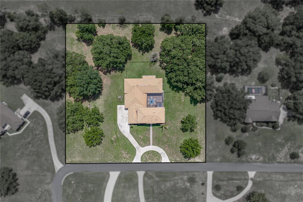 An aerial view shows a house with a pool cage surrounded by rural green fields — 37624 SKY RIDGE CIRCLE, DADE CITY, FL