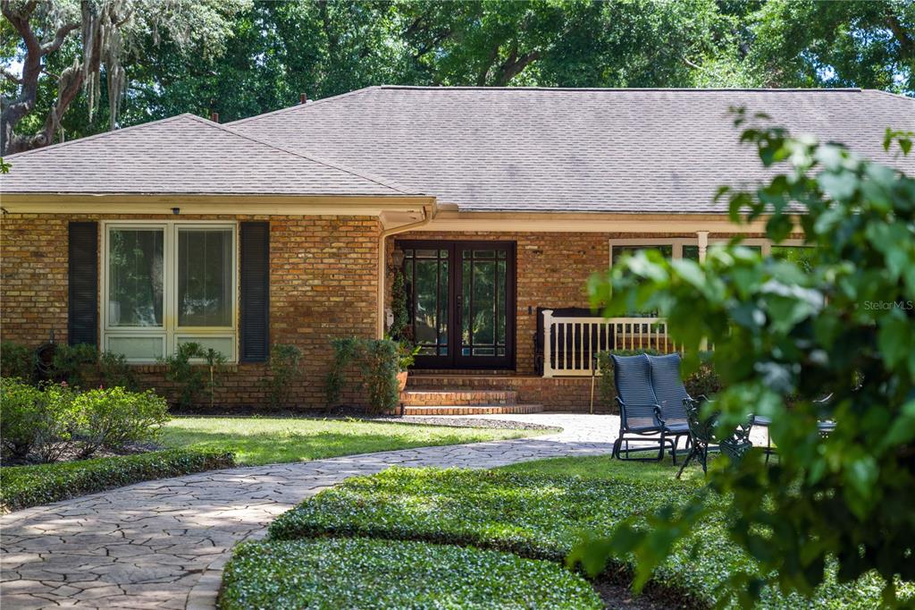 A brick house with a stone walkway leading to a double front door — 2009 WOODY DRIVE, WINDERMERE, FL