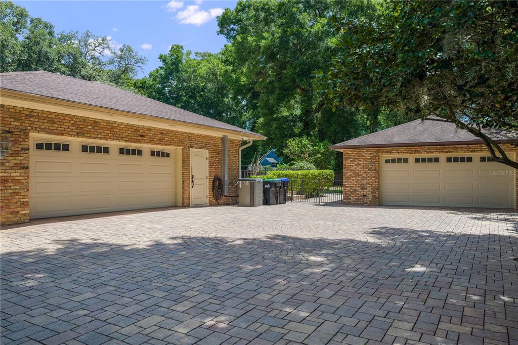 A brick house features two separate garages and a large paved circular driveway — 2009 WOODY DRIVE, WINDERMERE, FL