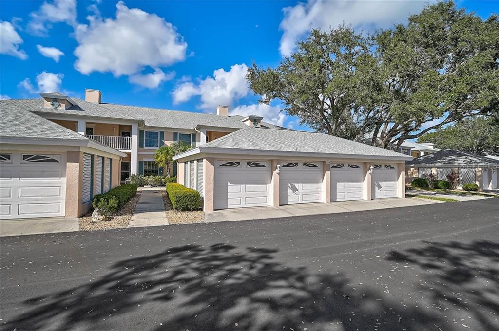 A row of residential garages sits in front of a two-story apartment building — 4219 CADDIE DRIVE E UNIT 204, BRADENTON, FL