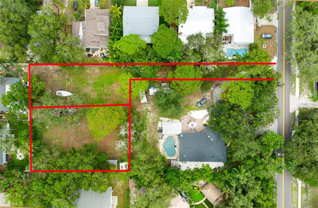 A large, grassy, sunlit backyard features mature trees and a small shed in the distance — 0 PENNSYLVANIA AVENUE, PALM HARBOR, FL