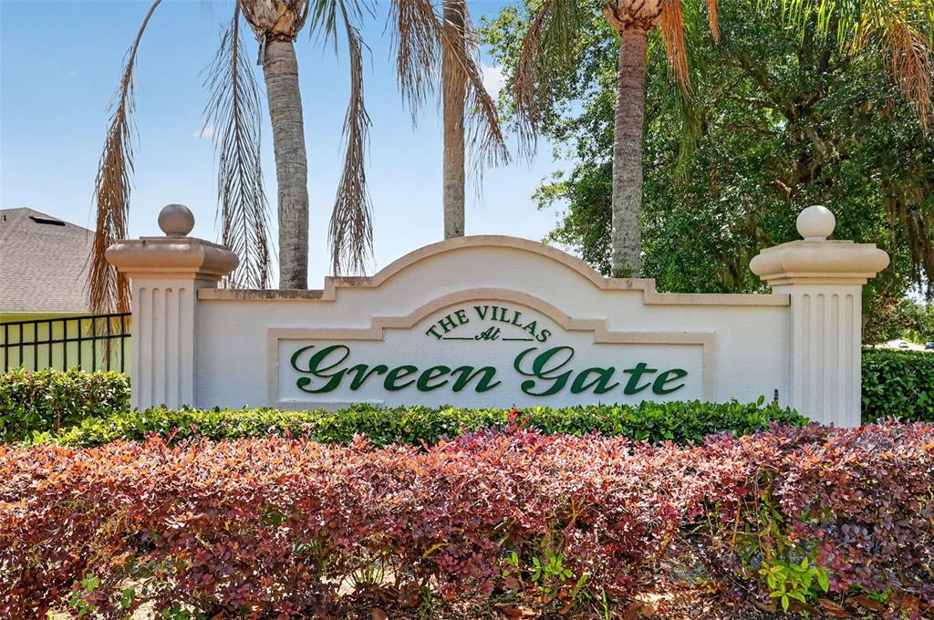 A kitchen with wood cabinets, granite countertops, and a breakfast bar opens to a dining area — 1010 GREEN GATE BOULEVARD, GROVELAND, FL