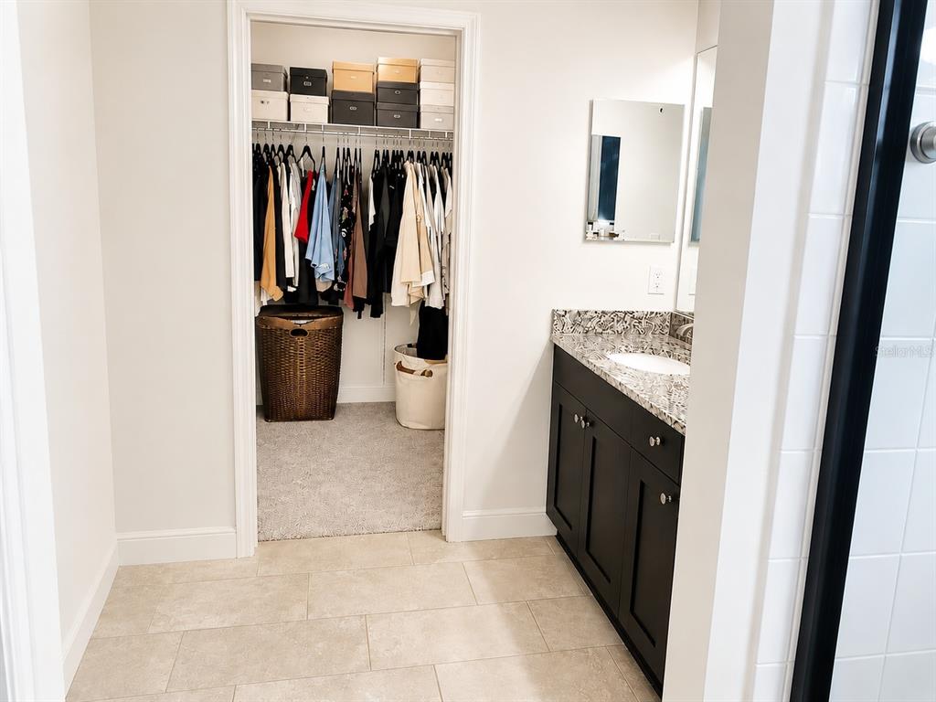 A kitchen features dark cabinetry, granite countertops, a tiled backsplash, and a large center island — 3516 WOODMONT DRIVE, PARRISH, FL