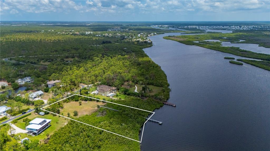 An aerial view shows a vacant waterfront lot outlined in white next to a river — 0 RIVERFRONT DRIVE Lot 6, VENICE, FL