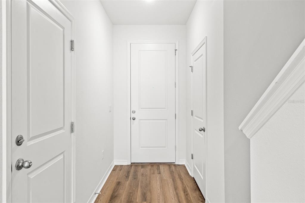 A modern kitchen features white cabinets, quartz countertops, a center island, and stainless steel appliances — 1156 CYPRESS ELM DRIVE, DELAND, FL