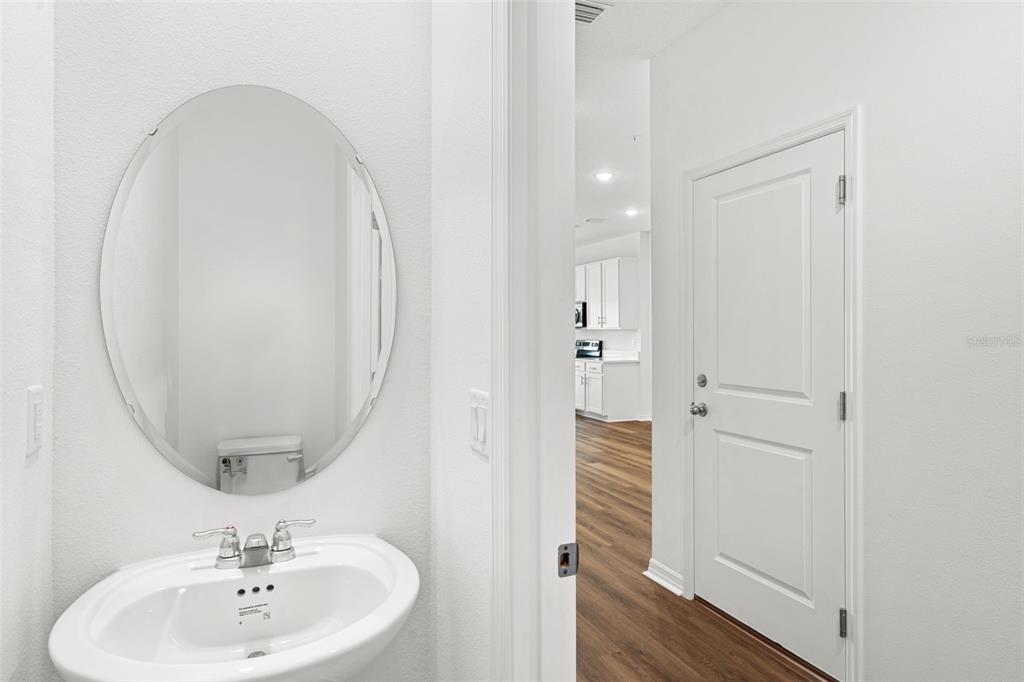 An open-concept kitchen and living area features white cabinetry, an island, and wood-look flooring — 1156 CYPRESS ELM DRIVE, DELAND, FL