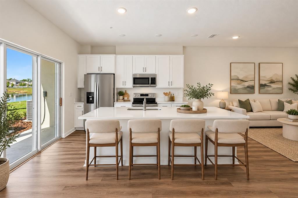 This is a digital rendering of an open-concept living room and kitchen with white cabinetry — 1156 CYPRESS ELM DRIVE, DELAND, FL