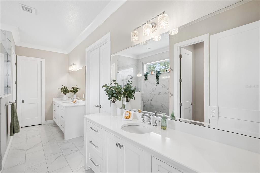 A kitchen features white cabinets, granite countertops, a stainless steel sink, and a built-in cooktop — 2370 PINE MEADOWS PLACE, OVIEDO, FL