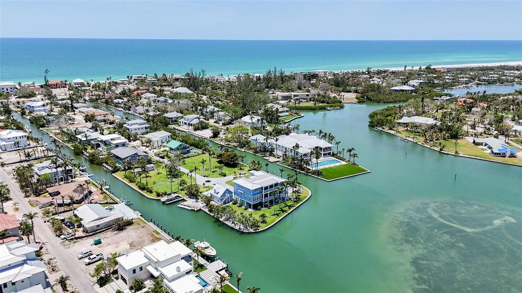 An aerial view shows waterfront homes along canals leading to the ocean — 630 DE NARVAEZ DRIVE, LONGBOAT KEY, FL