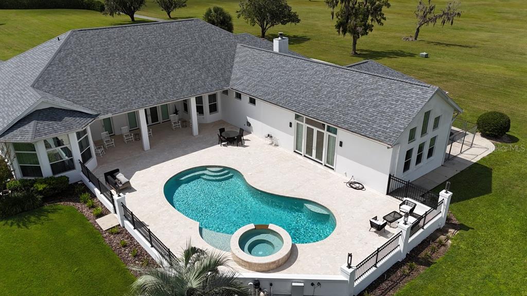 An aerial view shows a house with a pool, spa, and patio in a backyard — 601 SE 80TH STREET, OCALA, FL