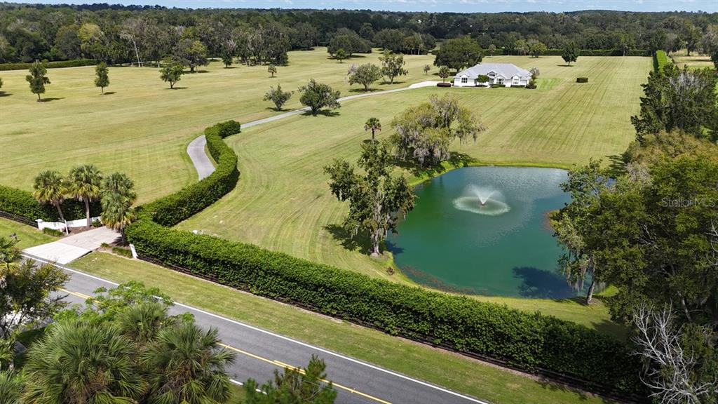 An aerial view shows a house, a pond with a fountain, and a long driveway — 601 SE 80TH STREET, OCALA, FL
