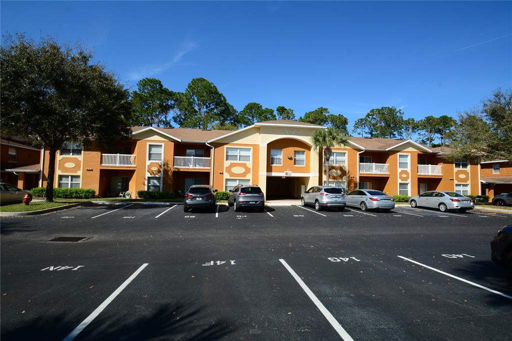 A multi-story apartment building with a parking lot in the foreground under a clear sky — 4600 E MOODY BOULEVARD UNIT 8D, BUNNELL, FL