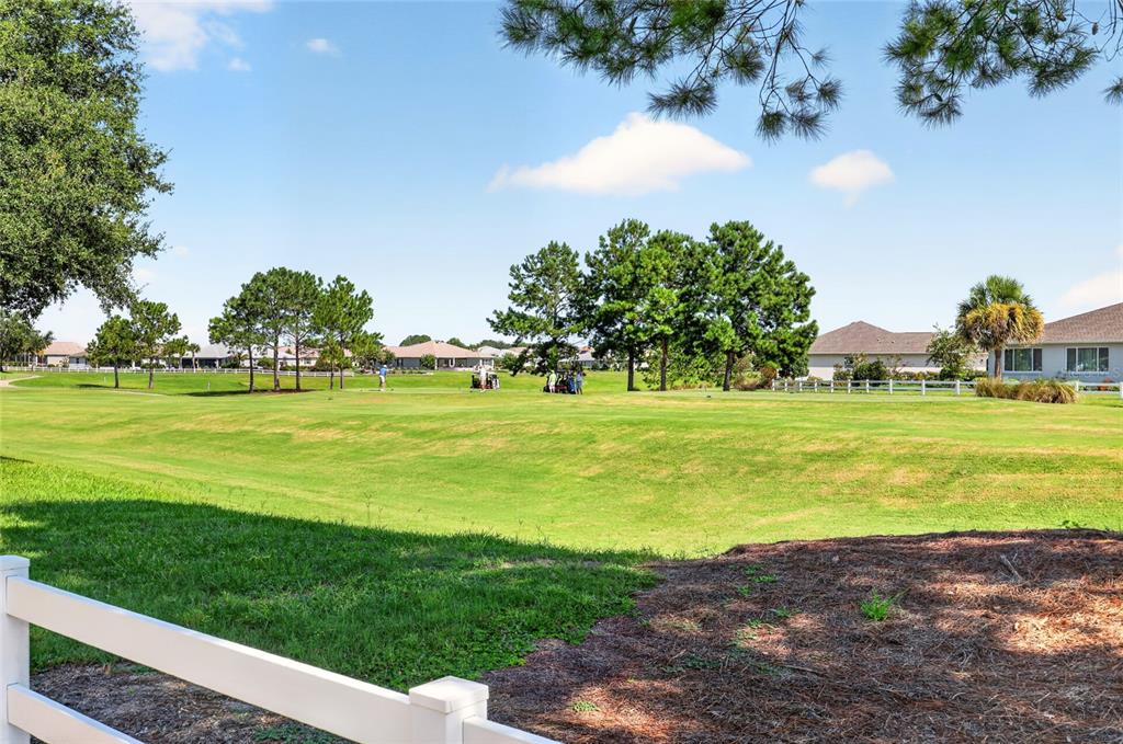 A single-story house with a stone facade, white stucco walls, and a paved driveway — 8889 SW 86TH LOOP, OCALA, FL