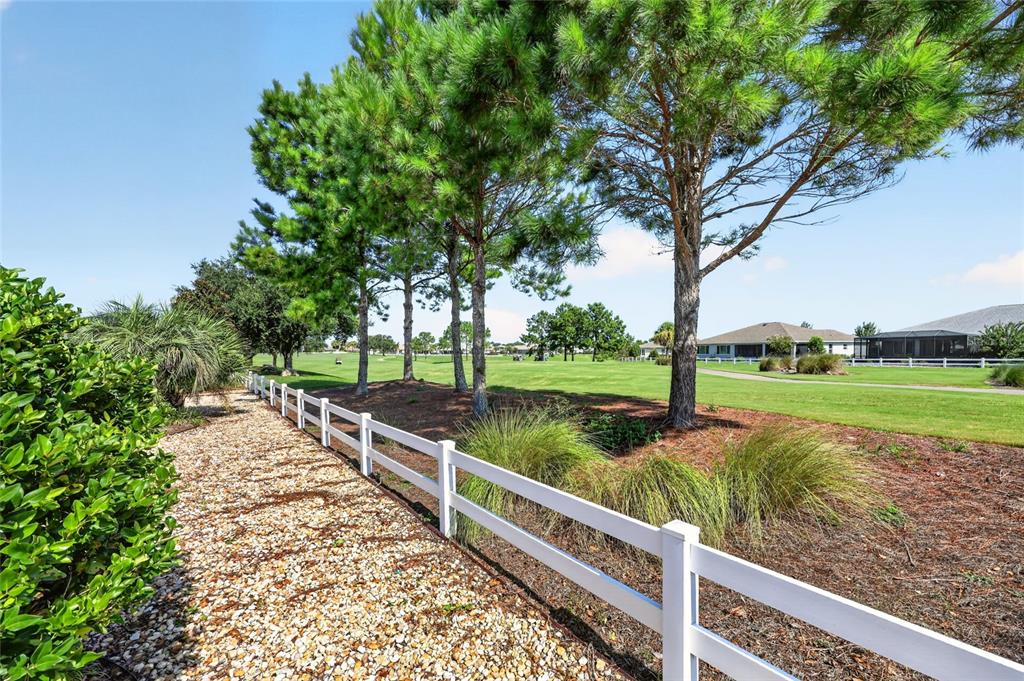 A single-story house with a gravel front yard, a palm tree, and manicured landscaping — 8889 SW 86TH LOOP, OCALA, FL