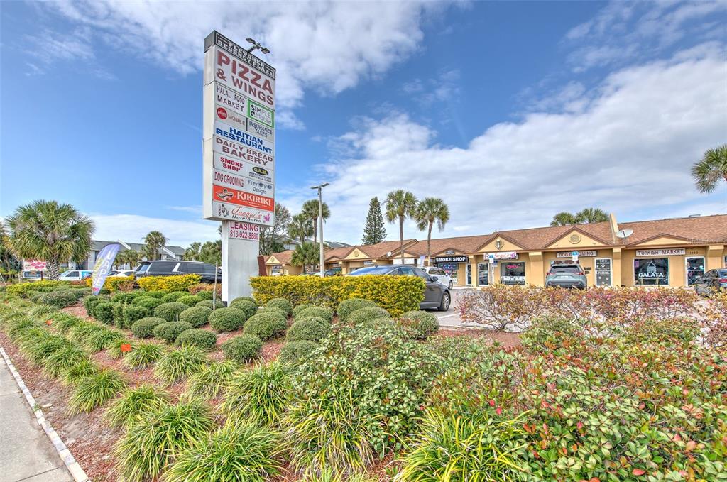 A commercial strip mall features a tall directory sign and a landscaped parking lot — 1402 E FLETCHER AVENUE UNIT 1426, TAMPA, FL