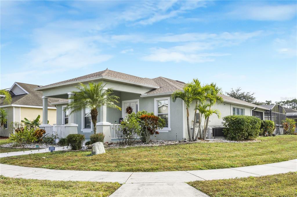 A light green single-story house with a covered front porch and palm trees — 4988 BOND STREET W, KISSIMMEE, FL