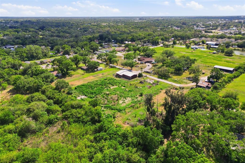 An aerial view shows a rural property with several buildings, trees, and open grassy fields — SHELL POINT ROAD, RUSKIN, FL