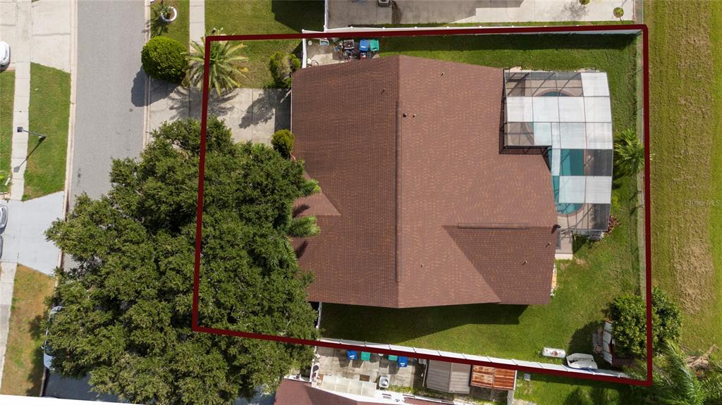 An aerial view shows a house with a brown roof, a pool cage, and landscaping — 12017 FAMBRIDGE, ORLANDO, FL