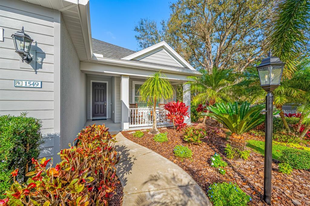 A concrete walkway leads to the front porch of a house with light gray siding — 1549 WESTOVER AVENUE, PARRISH, FL