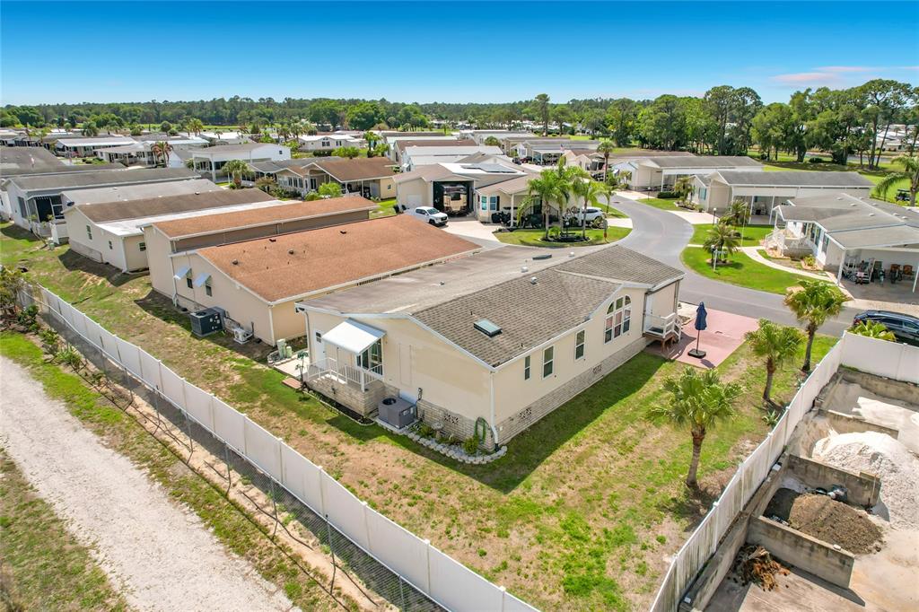 An aerial view shows a light-colored manufactured home with a brown roof in a community — 452 PAR DRIVE, FROSTPROOF, FL