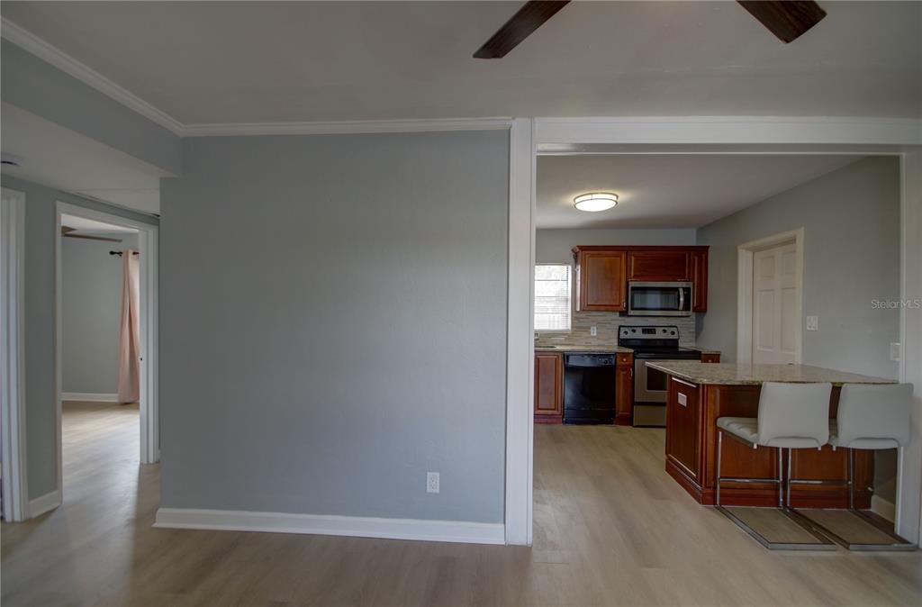 A view from a living area looking into a kitchen with wood cabinets and island — 820 86TH AVENUE N, ST PETERSBURG, FL
