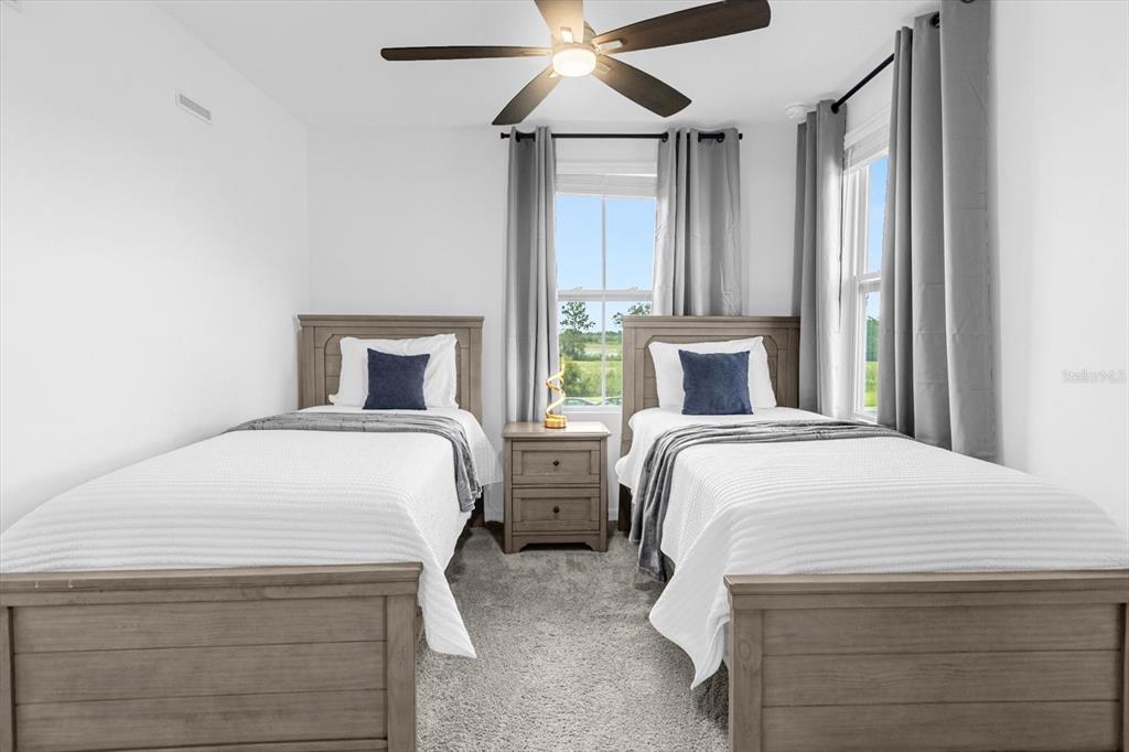 A bedroom features two twin beds with wooden frames, a central nightstand, and gray curtains — 935 CONCH ROAD, DAVENPORT, FL