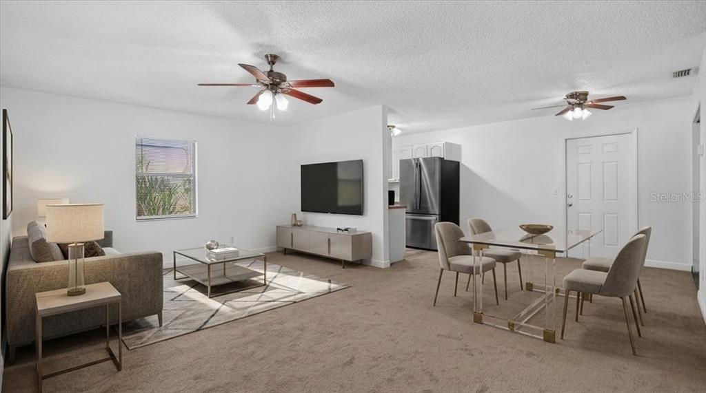 A living and dining area features carpeted floors, a ceiling fan, and a glass-topped table — 12641 116TH LANE, SEMINOLE, FL