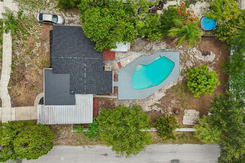 An aerial view shows a house with a dark roof, a swimming pool, and trees — 1004 WASHINGTON AVENUE, LARGO, FL