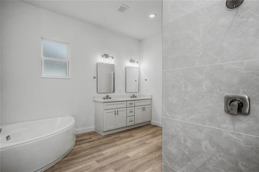A bathroom features a double vanity, a corner soaking tub, and a tiled walk-in shower — 7565 N SANTOS DRIVE, CITRUS SPRINGS, FL