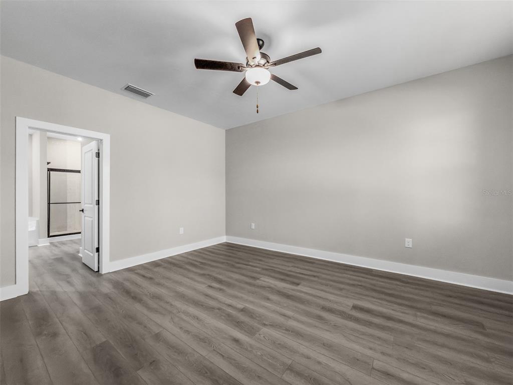 An empty bedroom features light gray walls, wood-look flooring, and a ceiling fan — 2411 GALLAGHER ROAD, DOVER, FL