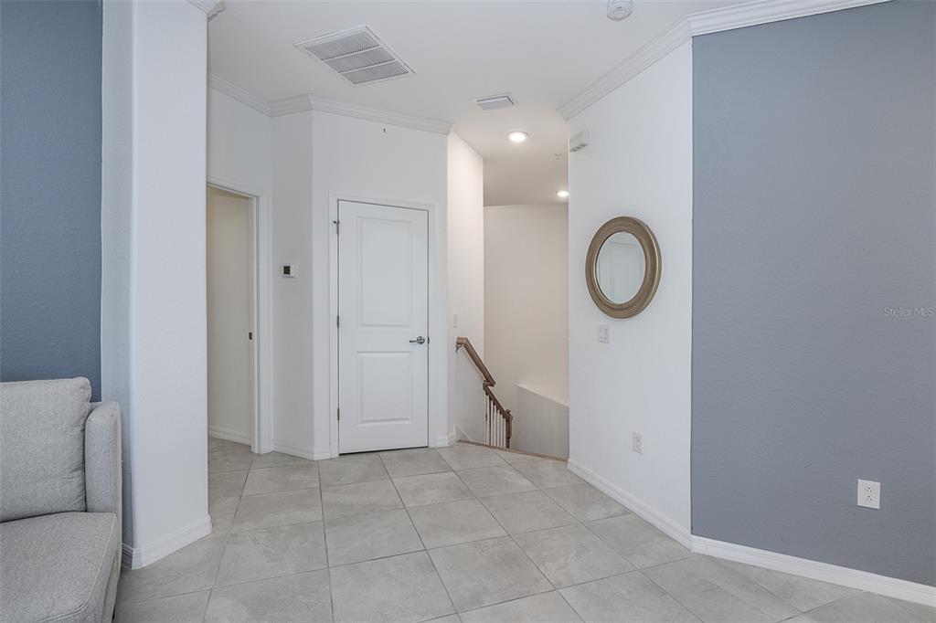 A tiled entryway features a white door, a staircase, and blue accent walls — 14132 POPPY FIELD LOOP UNIT 4022, PUNTA GORDA, FL