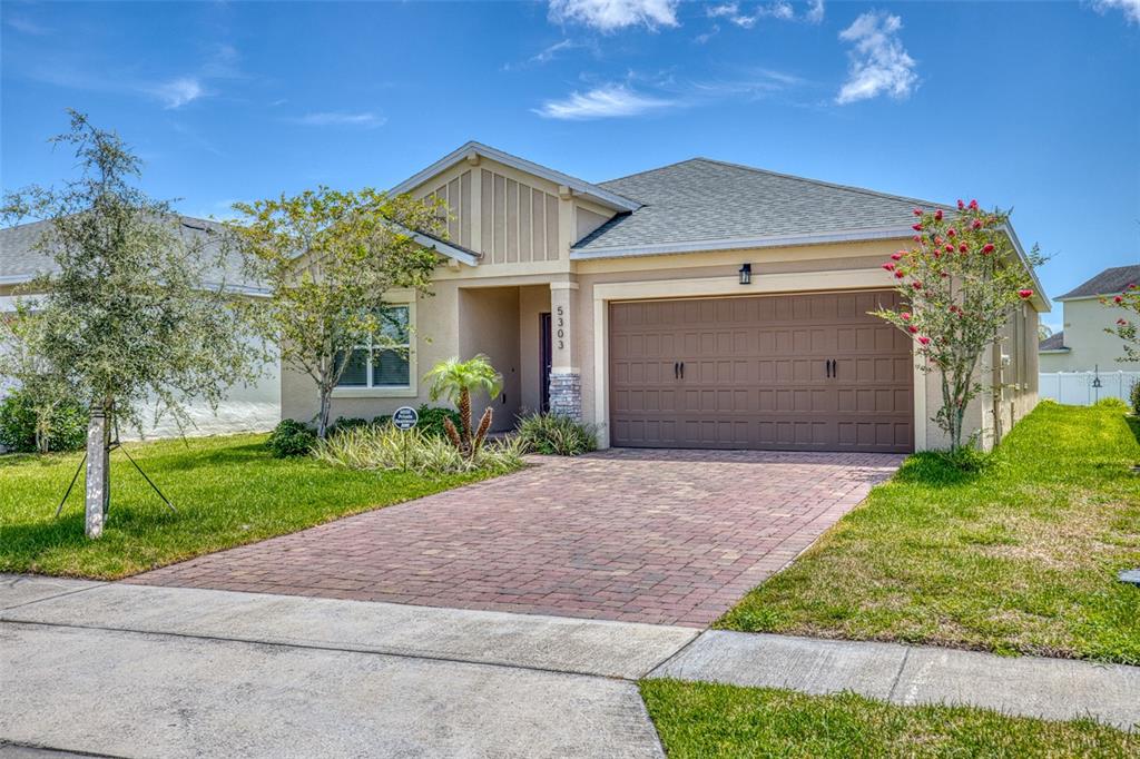 A single-story house with a brick paver driveway, a two-car garage, and a landscaped yard — 5303 CALADESI, PORT ORANGE, FL