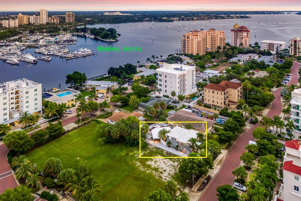 An aerial view shows a residential building highlighted in yellow near a marina and park — 161 GOLDEN GATE POINT, SARASOTA, FL