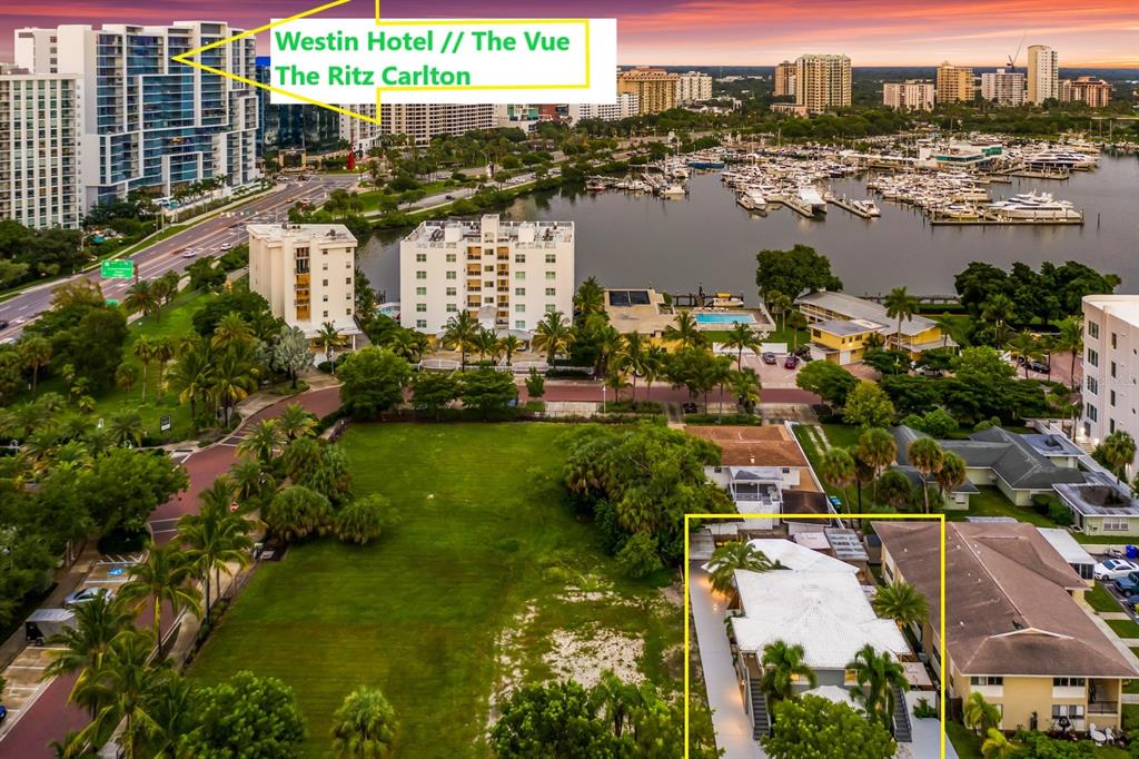 An aerial view shows a vacant lot, nearby residential buildings, a marina, and distant hotels — 161 GOLDEN GATE POINT, SARASOTA, FL