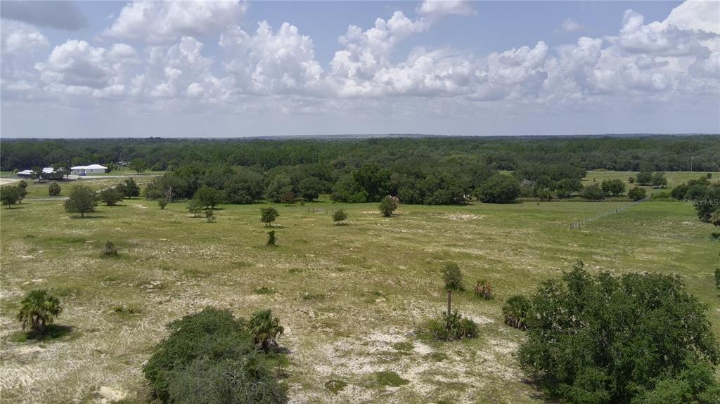 An aerial view of a large, grassy, undeveloped lot with scattered trees and distant buildings — 4547 GLEN SAINT MARY RD ROAD, LAKE WALES, FL