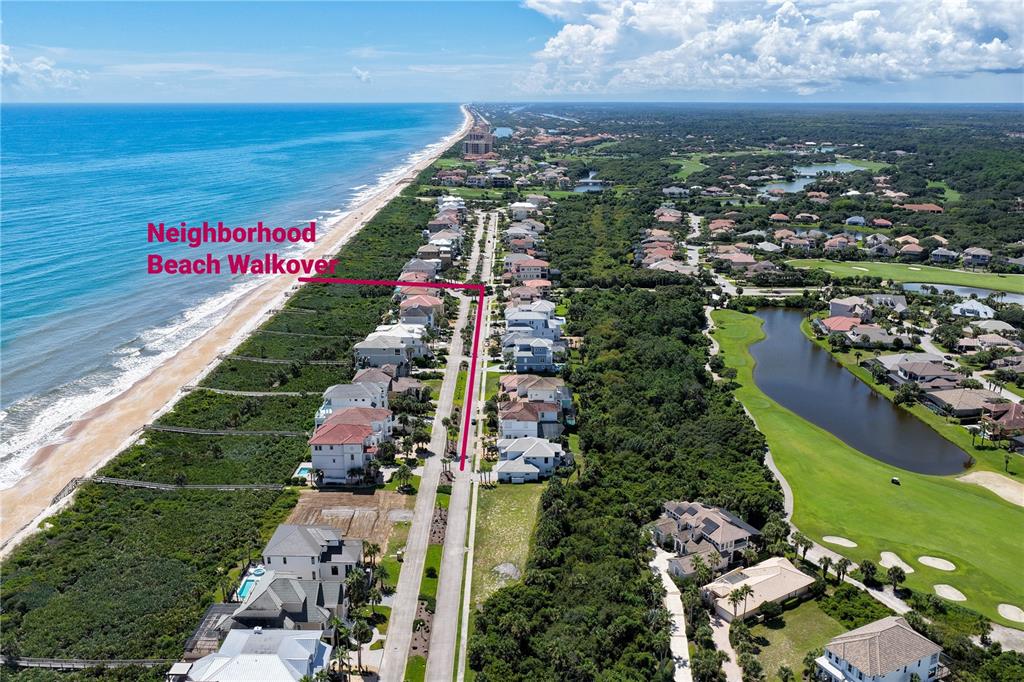 An aerial view shows a coastal neighborhood with houses, a golf course, and a beach walkover — 23 OCEAN RIDGE BOULEVARD N, PALM COAST, FL