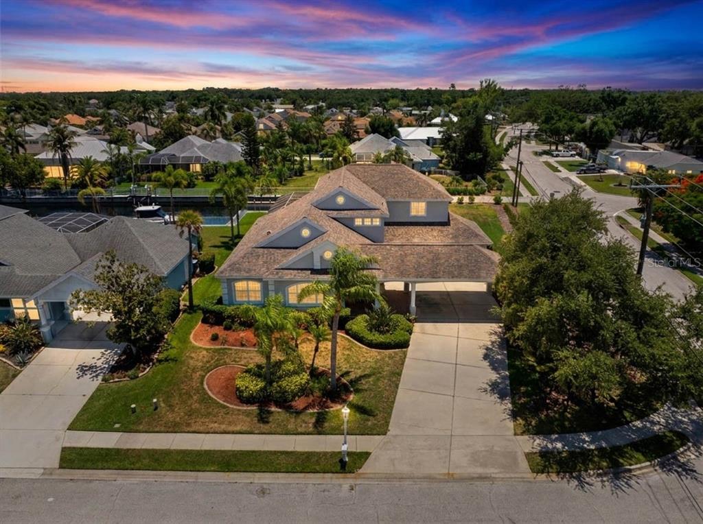 An aerial view shows a two-story house with a shingled roof and a concrete driveway — 4306 BARRACUDA DRIVE, BRADENTON, FL